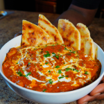 chicken tikka masala in bowl with naan