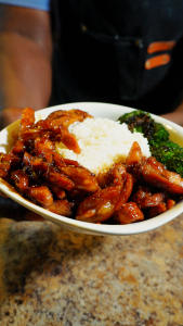 bourbon chicken in a bowl with broccoli and white rice