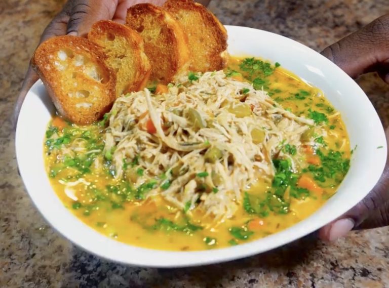 Chicken Noodle Soup in a bowl with crustinis and topped with parsley