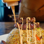 pouring yum yum sauce over steak fried rice