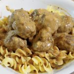 swedish meatballs over egg noodles in a bowl
