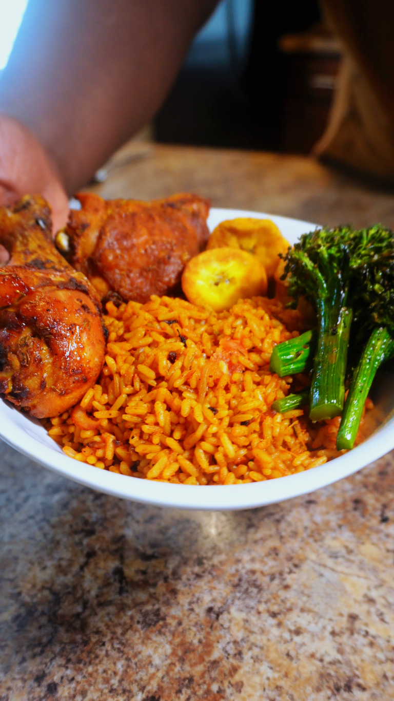 Jollof rice in bowl with plantain chicken and broccoli