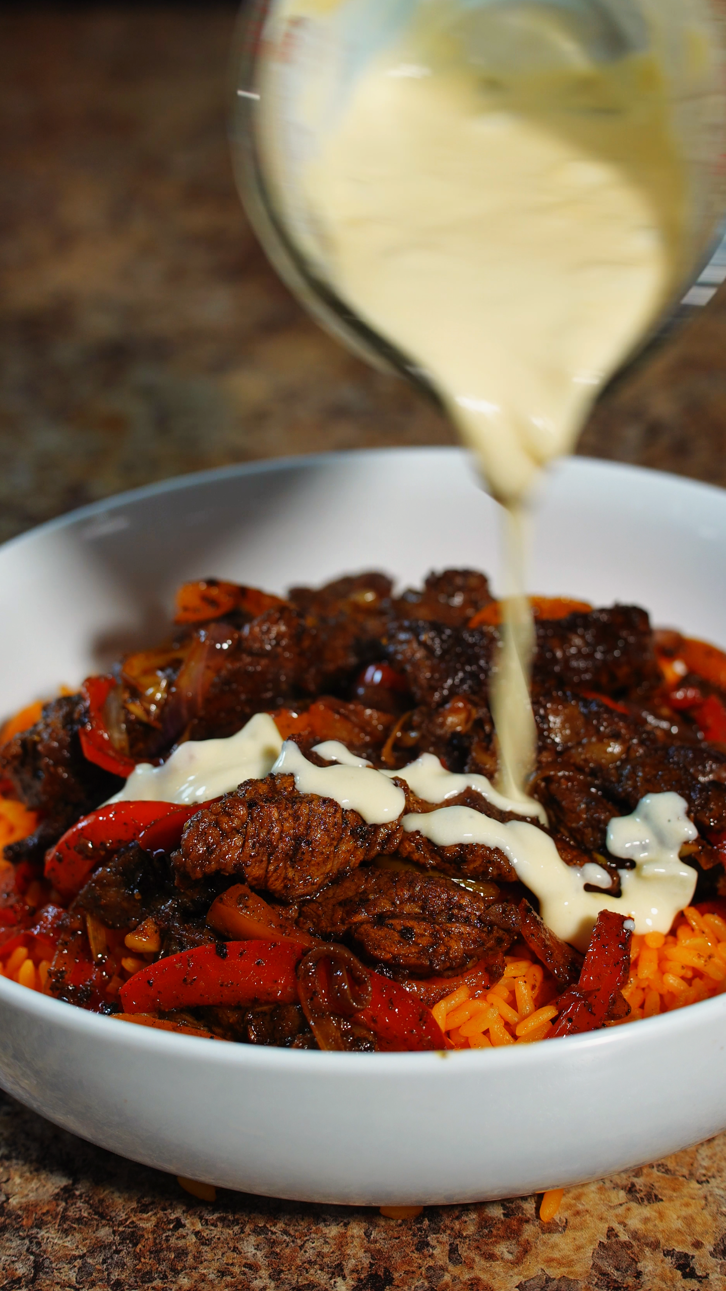 Steak Fajitas over Mexican Rice with queso drizzled on top