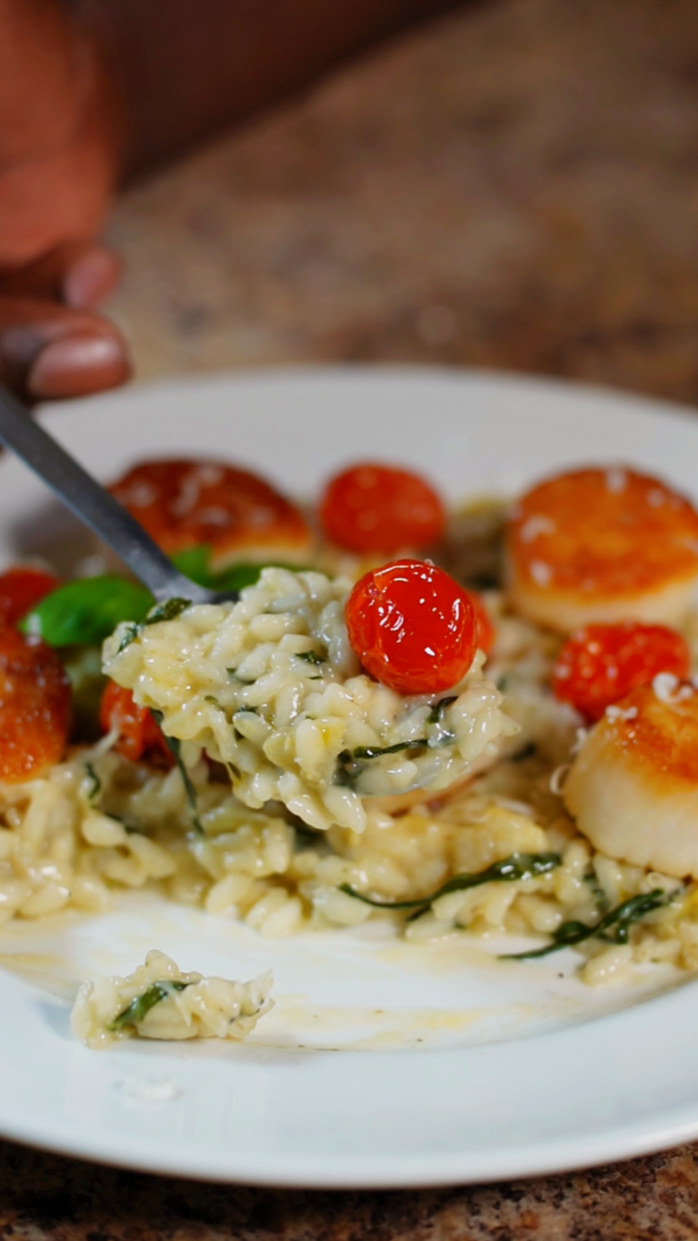 spinach and artichoke risotto with roasted cherry tomato on a spoon